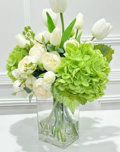 a vase filled with white and green flowers