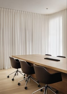 an empty conference table with four chairs in front of it