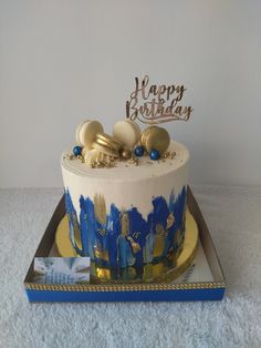 a birthday cake with blue and gold decorations