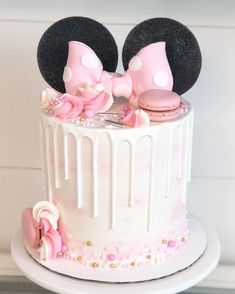 a minnie mouse cake decorated with pink and white frosting