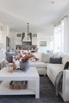 a living room filled with furniture and a white coffee table in front of a window