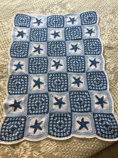 a blue and white crocheted blanket with stars on it