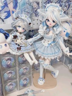 two dolls are standing next to each other in front of some shelves with stuffed animals