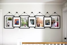 a wall with pictures hanging on it and a baby crib in the foreground