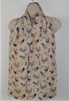 a woman's blouse with roosters on it is hanging from a hanger