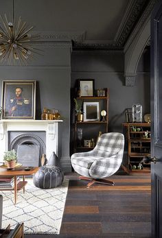 a living room filled with furniture and a fire place under a chandelier hanging from the ceiling