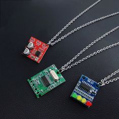 "3 Circuit Board Pendant Necklace.Made in Electronic parts and Resin, the pendant necklace with futuristic cyberpunk design, mixed production of environmentally friendly electronic originals, light and anti-stress material, cute colors, smart and interesting. Style A:Microphone amplification module, 20-200x amplification Style B:USB2.0 Expansion Module HUB  Style C:4-digit power indicator LED, 12V battery 4-segment power indicator module indicator Because they are handmade. each one will have a ittle difference.The unique and cute style of this necklace makes it perfect for wearing as an everyday keepsake. When she/he wears, she/he will have a reminder that your love is forever. This 316l stainless steel chain will not turn vour skin green, red. or itchy, The chain is dainty but strong. Gr Pcb Jewelry, Blue Cyberpunk, Couple Y2k, Cyberpunk Accessories, Couple Mignon, Futuristic Jewelry, Futuristic Cyberpunk, Necklaces Red, Cyberpunk Design