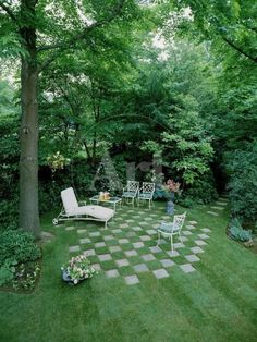 a garden with lawn furniture and trees in the background