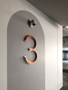 the letter c is mounted to the wall next to an arched doorway and light fixture