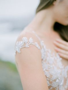 a close up of a woman wearing a wedding dress and holding her arm around her shoulder