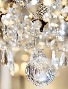 a crystal chandelier hanging from the ceiling in a room with lights on it