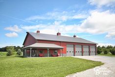 a large red barn sitting on top of a lush green field