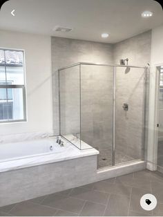 a bathroom with a walk in shower next to a bath tub