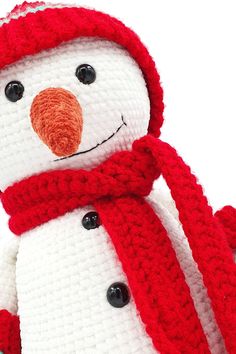 a crocheted snowman wearing a red hat and scarf