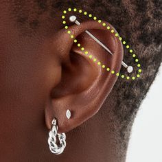 a woman with ear piercings on her left side and green dots in the middle