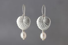 Silver & Pearl Earrings - These lightweight silver lily pads gracefully dangle from the ear.  Originally crafted from sterling silver sheet, they have been cast and finished with a satin texture and finished with a freshwater pearl.<br><br>To clean, liquid dip is recommended to maintain the bright silver luster; follow instructions on bottle regarding pearls.<br><br>Available in three finishes: bright silver, vermeil, and oxidized silver. Silver Clay Earrings, Pmc Earrings, Pearl Jewellry, Silversmithing Jewelry, Art Clay Silver, Clay Silver, Satin Texture, Beaded Chandelier Earrings, Plant Jewelry