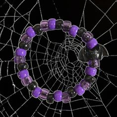 a spider web with purple and black beads