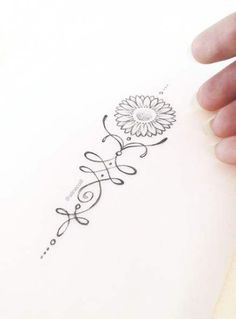 a hand holding a piece of paper with a flower on it and the word love written in cursive writing