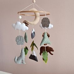 a baby crib mobile with animals and clouds hanging from it