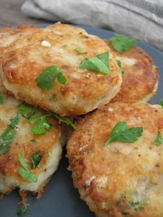 four crab cakes on a blue plate with parsley