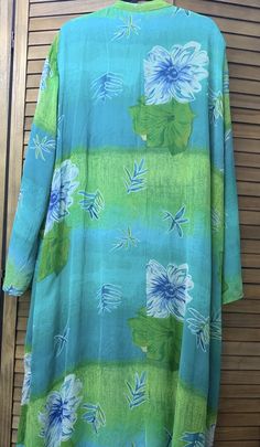 This Studio by Valerie Stevens garment is a beautiful shades of green summer dress/Kaftan in size 3X  This beautiful fully lined Kaftan/long dress in shades of green is perfect to be a beach/pool coverup or a dress for a casual summer event.  Features include a wispy shell with stylized flowers on a variegated green background.  The garment is lined except for the sleeves, has front buttons to below the chest, long sleeves, mandarin collar, and dual side vents in both the shell and the lining.  This garment could be dressed up for any casual summer party or used as a beach or pool cover-up. Size: 3X (please pay particular attention to the measurements below:) Shoulders: 21" Bust:29" (58" doubled) Waist:  28" (56" doubled) Hips:   28" (56" doubled) Sleeves: 25" Neckline to Hem: 51" Material Green Bohemian Maxi Dress With Tropical Print, Casual Green Dress For Beach Cover-up, Green Long Sleeve Maxi Dress For Summer, Green Tropical Print Maxi Dress For Beach Season, Bohemian Green Beach Dress With Tropical Print, Green Flowy Sundress For The Beach, Green Flowy Sundress Beach Dress, Flowy Green Sundress For Beach, Casual Green Beach Cover-up Dress