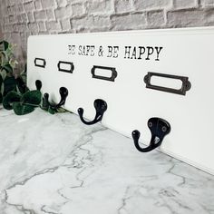 there are hooks on the wall that have been decorated with black letters and metal handles