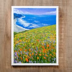 a painting of wildflowers on a hill by the ocean with water in the background