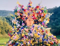 a woman with flowers on her head in the middle of a field