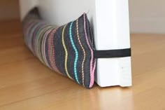 a close up of a pillow on the floor near a door frame with a strip of fabric tied to it