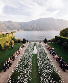 an aerial view of a wedding ceremony with flowers in the foreground and mountains in the background