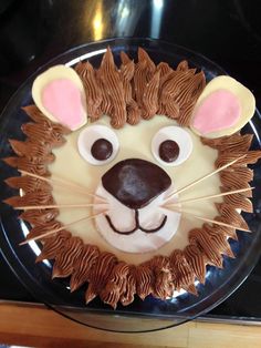 a cake decorated to look like a lion's head with ears and paws on it