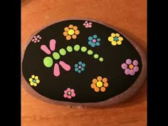 a painted rock sitting on top of a wooden table