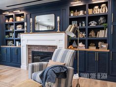 a living room filled with furniture and a fire place under a large mirror on top of a book shelf