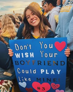 a girl holding a sign that says don't you wish your boyfriend could play like mine