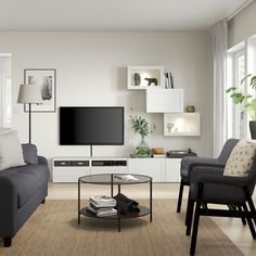 a living room filled with furniture and a flat screen tv mounted on a wall above a coffee table