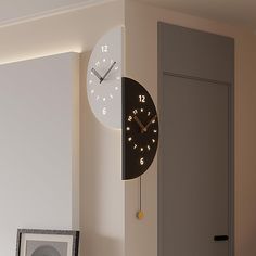 a clock that is on the side of a wall next to a framed photograph and an open door