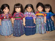 five dolls standing next to each other in dresses