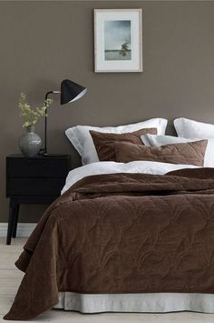 a bed with brown and white comforters in a bedroom