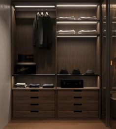 a walk in closet with clothes and shoes on the shelves next to each other,