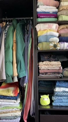 a closet filled with lots of folded clothes