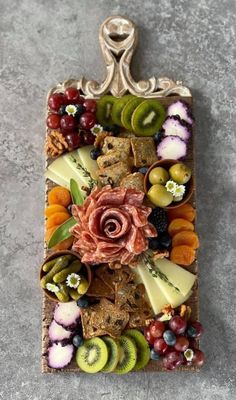 an artfully designed tray with fruit and cheese on it