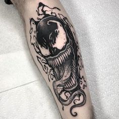 a black and white tattoo with an alien head on the arm, surrounded by tentacles