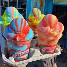 two scoops of ice cream in front of a candy shop with rainbow swirls