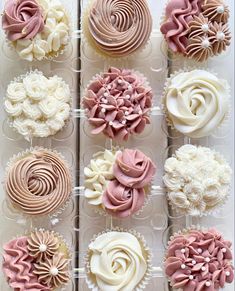 twelve cupcakes with pink and white frosting arranged in a display case on a table