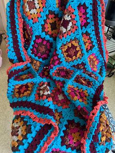 a crocheted blanket sitting on top of a chair