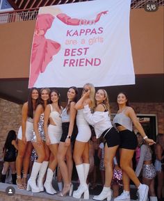 the girls are posing in front of a banner