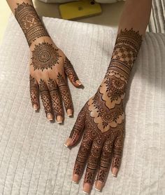 two hands with henna tattoos on them