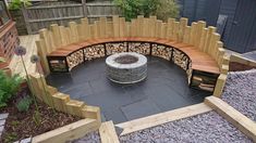 a wooden bench sitting next to a stone fire pit