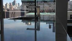 an empty table in front of a large window overlooking the cityscape and skyscrapers