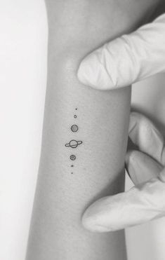 a woman's arm with three planets on it and the word love written in black ink